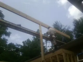 Carpenter setting a ridge beam over a new addition frame — Ice Dam Removal by Roofing Brothers in Genesee Depot