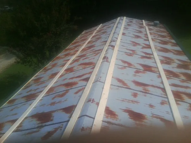 Rusted metal roof panels with new wood purlins before replacement — Storm Damage Roof Repair in Genesee Depot by Roofing Brothers