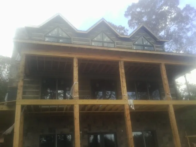 Dormers and porch framing on a large log home under construction — Roof Coating work by our crew in Genesee Depot